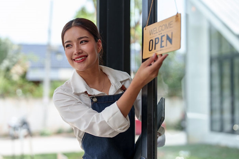 Shopkeeper putting up Open sign
