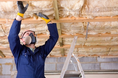 Worker installing ceiling insulation